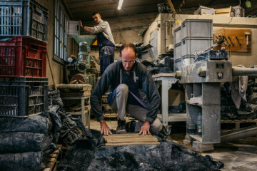 Frere Martin, Bruder der Communaute von Taize, mischt in einer Maschine verschiedene Tonerden zu Töpferton, Frere Bart verpackt den fertiggestellen Ton in der Töpferwerkstatt in Taize am 30. Oktober 2018.