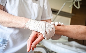 Eine Pflegerin reibt die Arme einer Patientin mit einem kühlendem Gel ein, am 10. Juli 2023 in einem Krankenhaus in Koblenz.