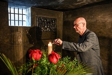 Christoph Kulessa, Geschäftsführer des Maximilian-Kolbe-Werks, zündet eine Kerze an im Hungerbunker, der Todeszelle von Maximilian Kolbe, in der KZ-Gedenkstätte Auschwitz I (Stammlager), am 22. September 2023 in Oswiecim (Polen).