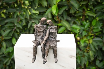 Bronzefigur mit einem Paar, das nah beieinander sitzt, auf einem fiktiven Grabstein am 18. Oktober 2023 auf dem "Campus Vivorum" in Süßen.