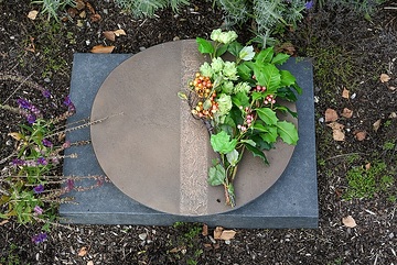 Ein fiktives Urnengrab ist mit einem Blumengesteck geschmückt, am 18. Oktober 2023 auf dem "Campus Vivorum" in Süßen.