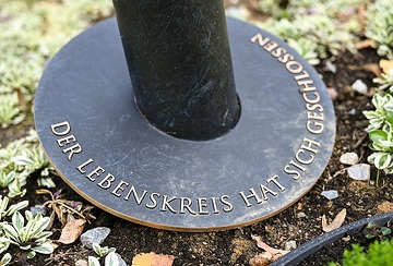 Stele auf einem fiktiven Grabfeld für Urnengräber am 18. Oktober 2023 auf dem "Campus Vivorum" in Süßen. Auf dem Sockel steht der Satz "Der Lebenskreis hat sich geschlossen".