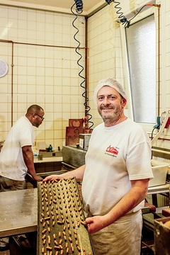 Thomas Merkelbach, Betriebsleiter der Printenbäckerei Klein, hält ein Backblech mit Printen am 30. Oktober 2023 in der Bäckerei in Aachen.