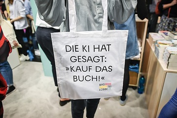 Eine Frau hält einen Stoffbeutel mit dem Schriftzug "Di KI hat gesagt: Kauf das Buch!» am 20. Oktober 2023 während der Buchmesse in Frankfurt.