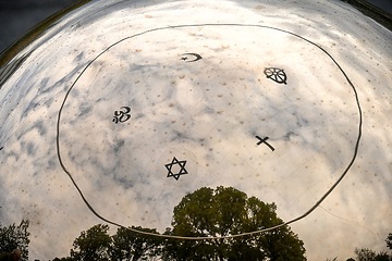 Die Symbole der fünf Weltreligionen Judentum, Christentum, Islam, Buddhismus und Hinduismus spiegeln sich in einer Bronzekugel, am 18. Oktober 2023 auf dem "Campus Vivorum" in Süßen.