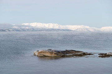 Bucht von Alta (Norwegen) am 12. Dezember 2023. Schnee bedeckt die Berge.