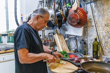 Chefkoch Mosche Basson bereitet ein traditionelles Essen mit Mariendisteln und Khubeza zu am 26. Februar 2024 in seiner Wohnung in Modi'in (Israel).