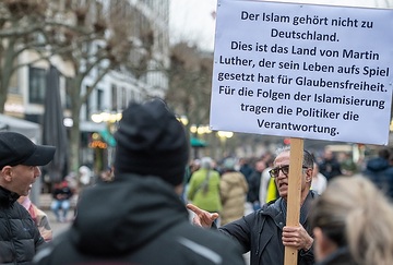 Ein Mann protestiert 
mit einem Plakat mit der Aufschrift "Der Islam gehört nicht zu Deutschland. Dies ist das Land von Martin Luther, der sein Leben aufs Spiel gesetzt hat für Glaubensfreiheit. Für die Folgen der Islamisierung tragen die Politiker die Verantwortung.", bei der erstmaligen Illumination mit Lichterschmuck zum islamischen Ramadan Fest in der Freßgass in Frankfurt am 10. März 2024.