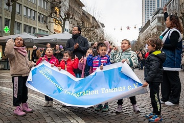 Kinder halten ein Banner mit der Aufschrift "Blühende Integration Taunus e.V." bei der erstmaligen Illumination mit Lichterschmuck zum islamischen Ramadan Fest in der Freßgass in Frankfurt am 11. März 2024.