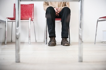 Eine Patientin sitzt vor ihrem Termin auf einem Stuhl im Wartezimmer einer Arztpraxis am 21. Dezember 2022 in Bonn.