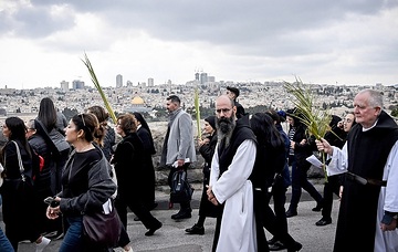 Teilnehmer mit Palmenblättern, darunter Ordensleute, während der Palmsonntagsprozession auf dem Ölberg in Jerusalem (Israel) am 24. März 2024.