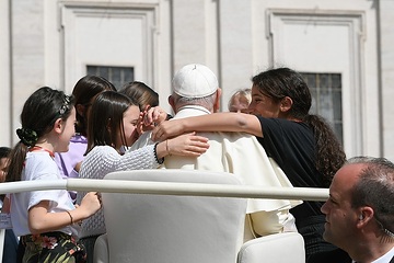 Papst Franziskus wird von Kindern umarmt bei der Generalaudienz am 17. April 2024 auf dem Petersplatz im Vatikan.
