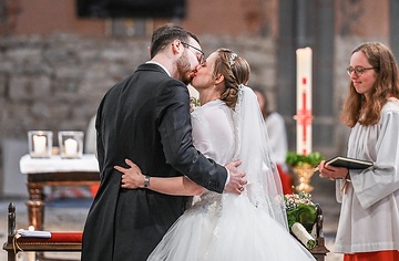 Ein Hochzeitspaar küsst sich bei einer Trauung am 20. April 2024 in der Kirche Sankt Laurentius in Bad Neuenahr-Ahrweiler.